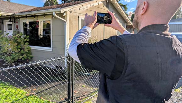 Michael Haines, certified professional home inspector and owner of Creekside Home Inspection Services taking a photo of the exterior of a home during a home inspection.
